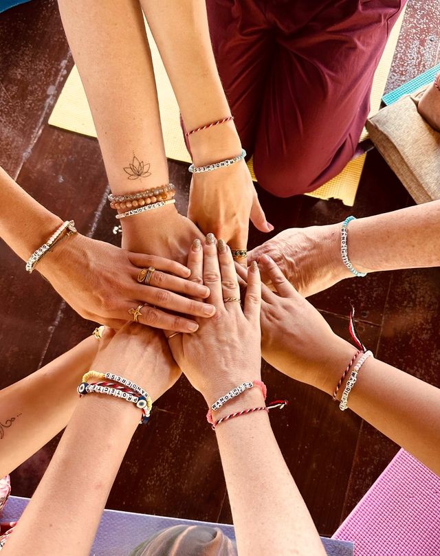 Eight hands stacked in the centre of a circle at the end of a session