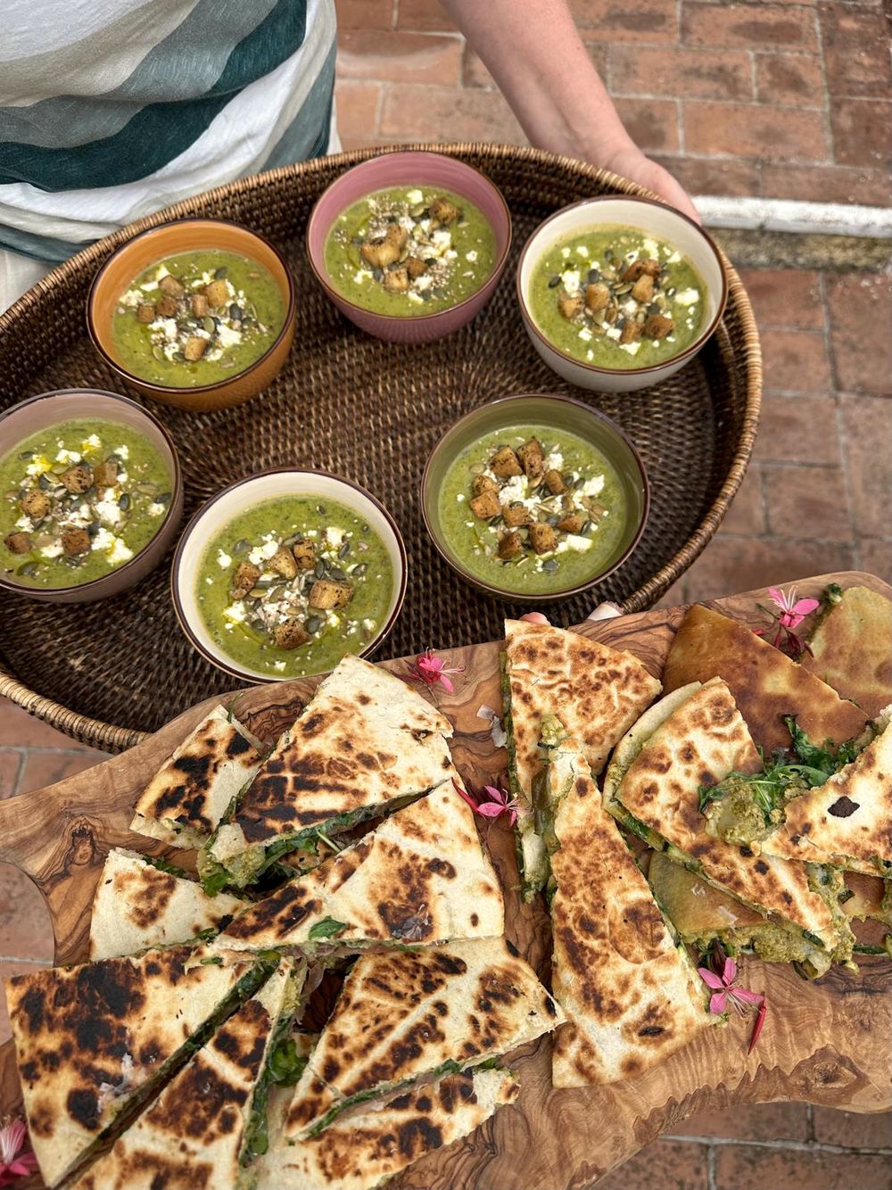 Focaccia and small plates on a scrubbed wooden table, hands reaching in