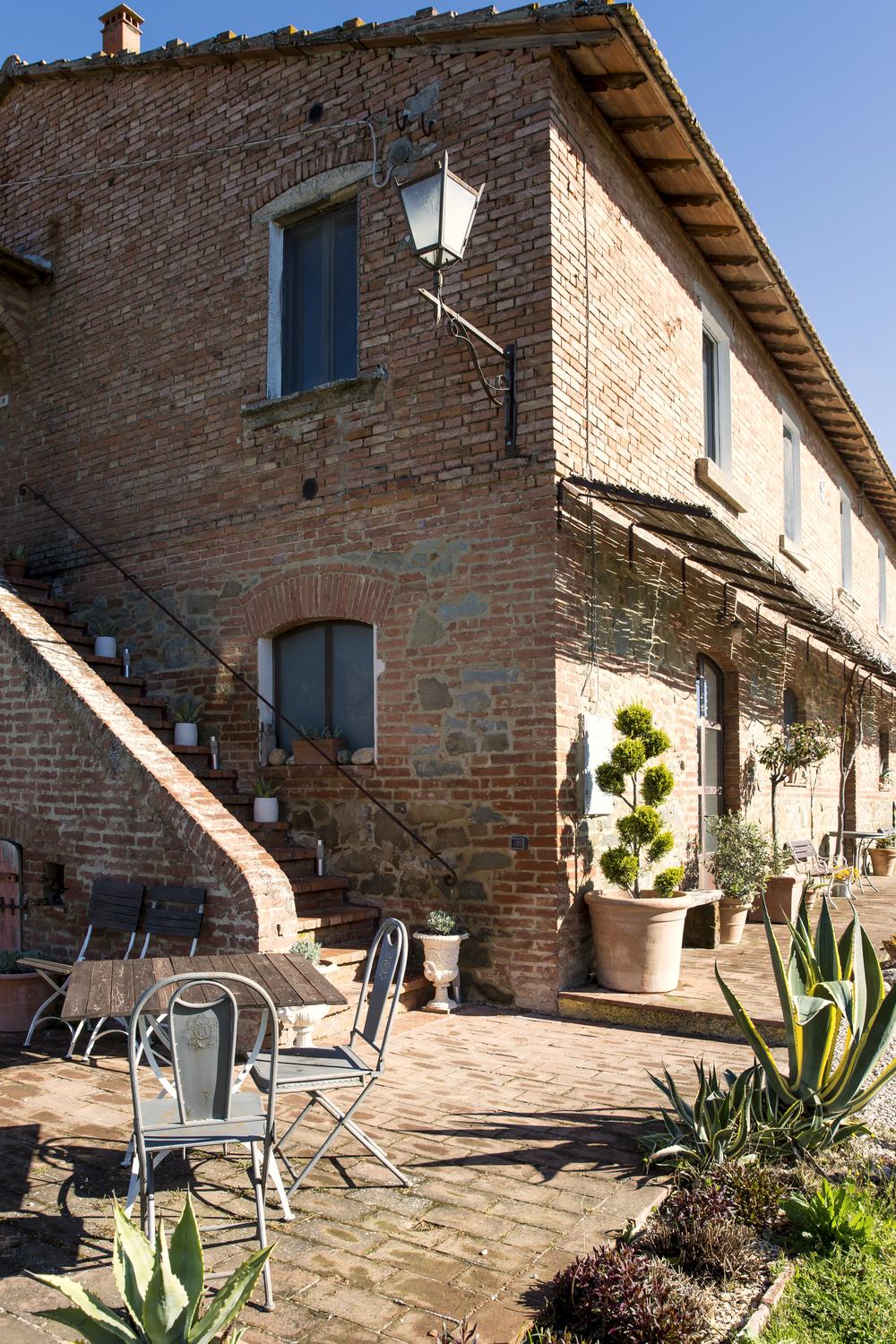 Siliano Alto seen from the lawn, the whole length of the farmhouse behind a single olive tree